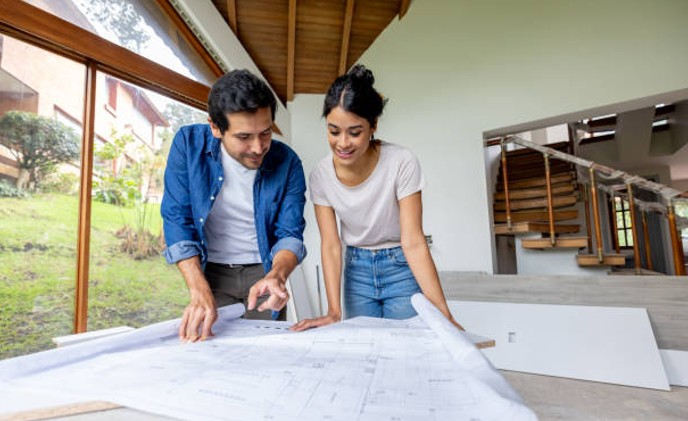 Homeowners reviewing remodeling plans with a contractor for a home renovation project