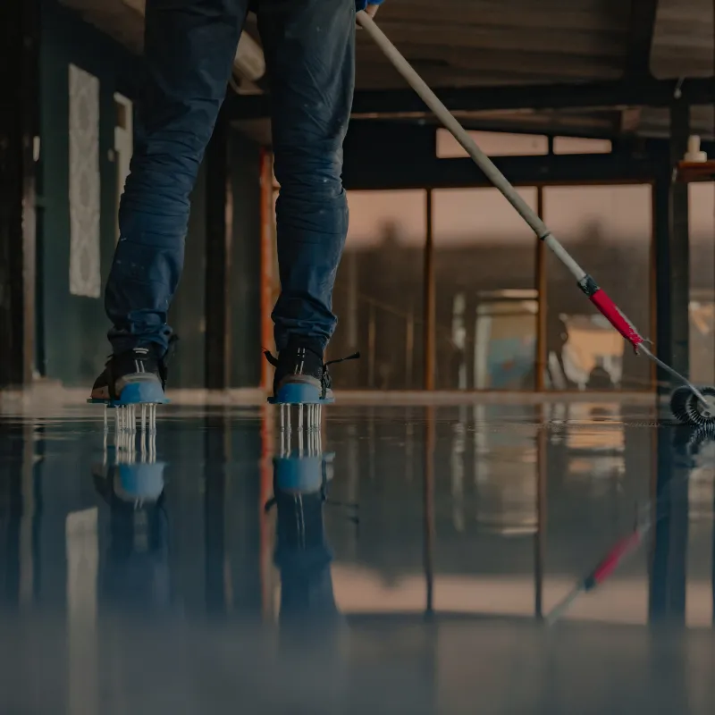 Installer wearing spiked shoes walking on fresh epoxy floor