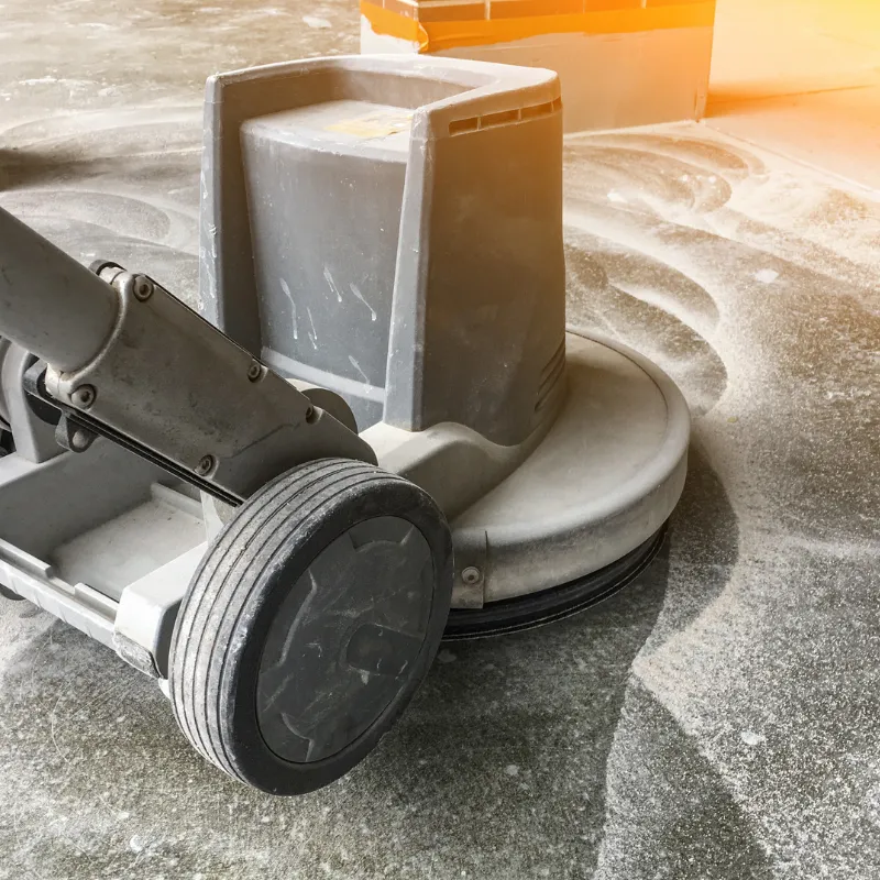 Concrete grinding machine preparing floor for epoxy coating