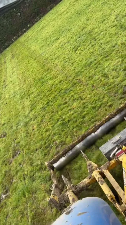View from inside tractor cab during aerating process on hillside paddock