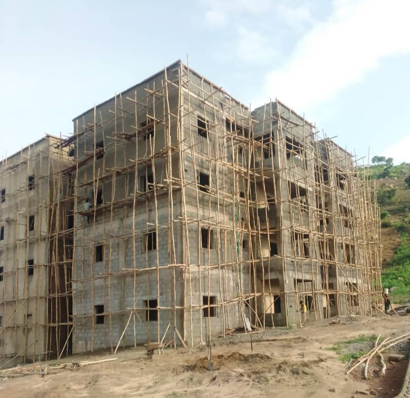 Active structural building construction site in Aba Abia State under warm sunlight