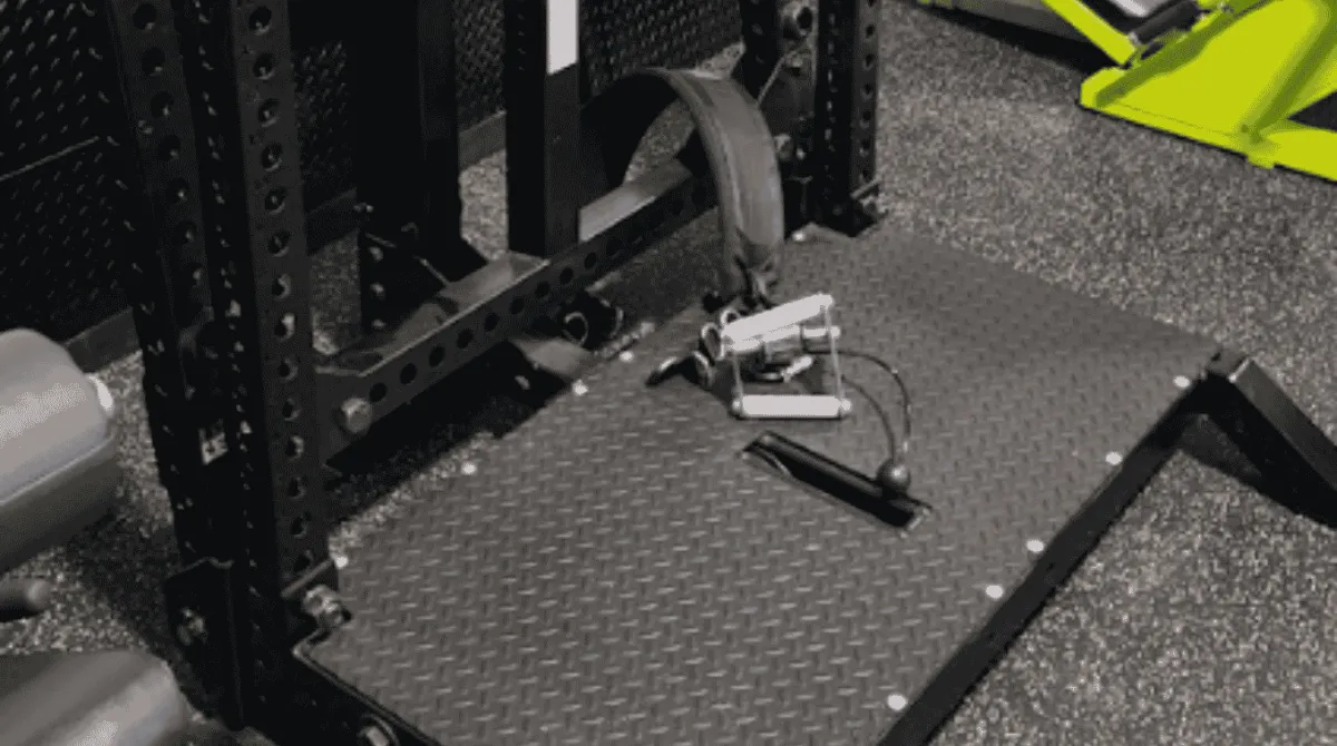 Close-up of an industrial black Rogue Rhino belt squat machine featuring a heavy-duty textured diamond-plate platform and structural steel frames at a premium strength training facility near Monroe, CT.