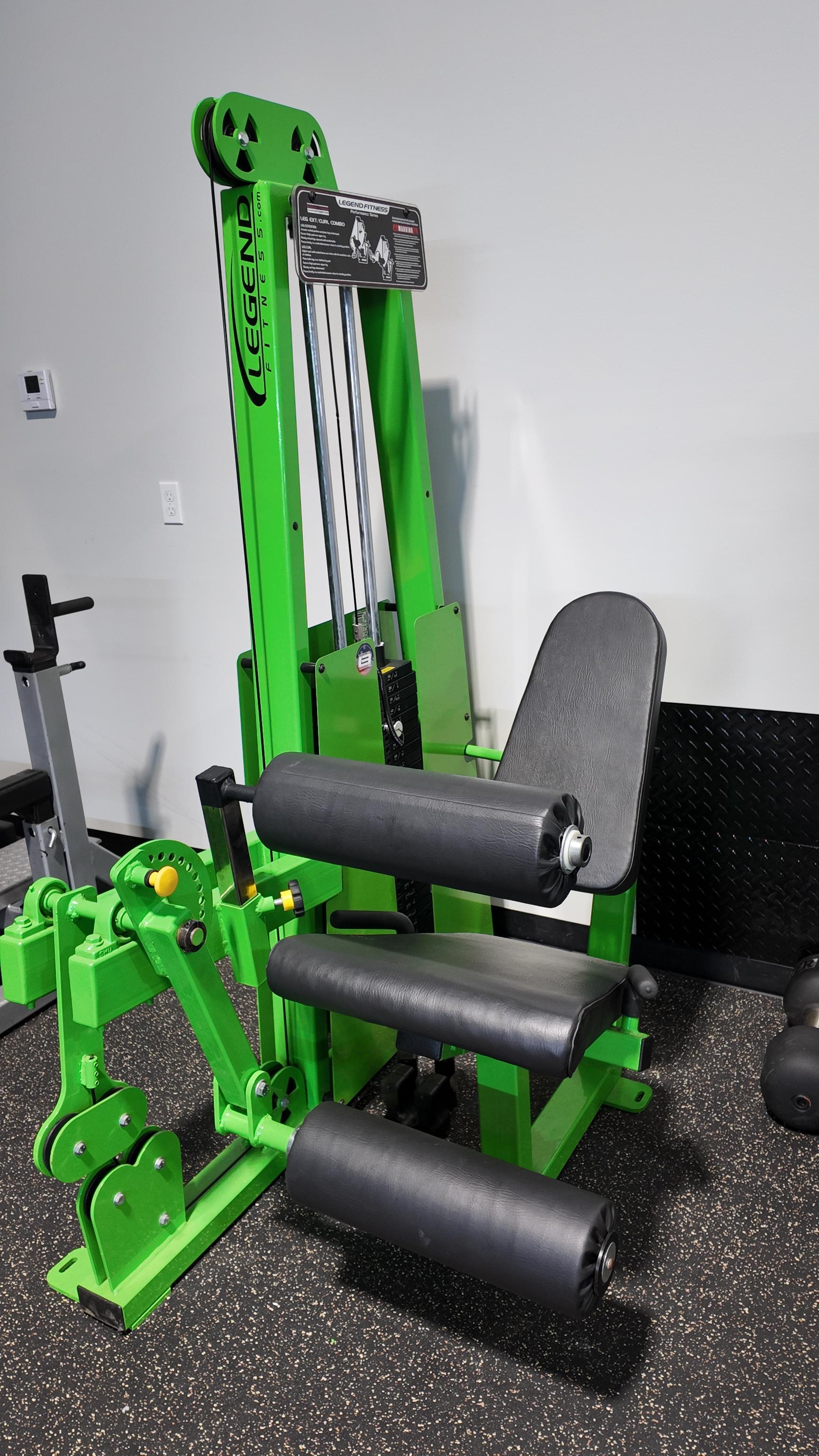 A custom toxic green Legend Fitness selectorized leg extension and seated leg curl machine with black leather upholstery on a rubber gym floor at The Strength Lab in Newtown, Connecticut.