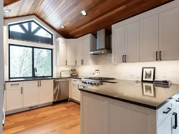 Custom kitchen renovation with white cabinets and black countertops.