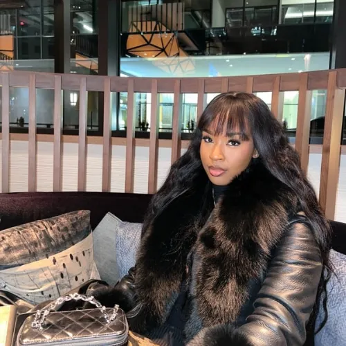 Elegant, confident woman in a modern office, reviewing financial documents with a sense of accomplishment. The background features soft, blurred cityscape through large windows, conveying professionalism and luxury. Warm, natural lighting enhances the premium atmosphere. 3:2 aspect ratio.