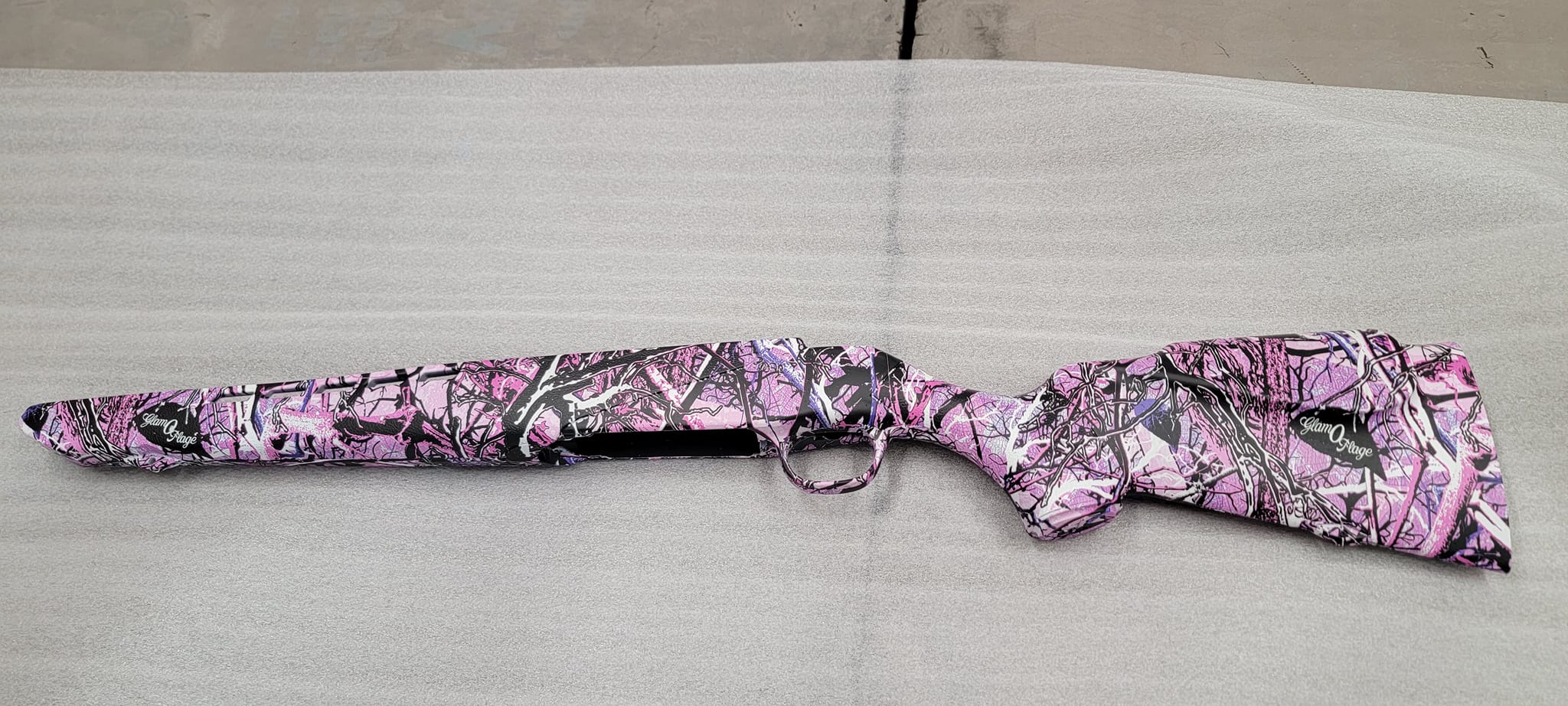 Rifle stock wrapped in pink, black, and white camo-style hydrographic pattern