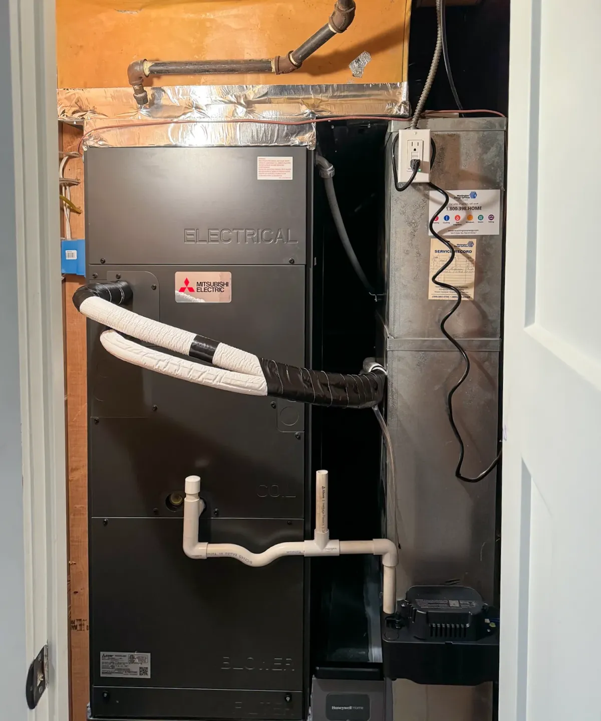 Technician servicing a residential gas and electric furnace in the Puget Sound Region