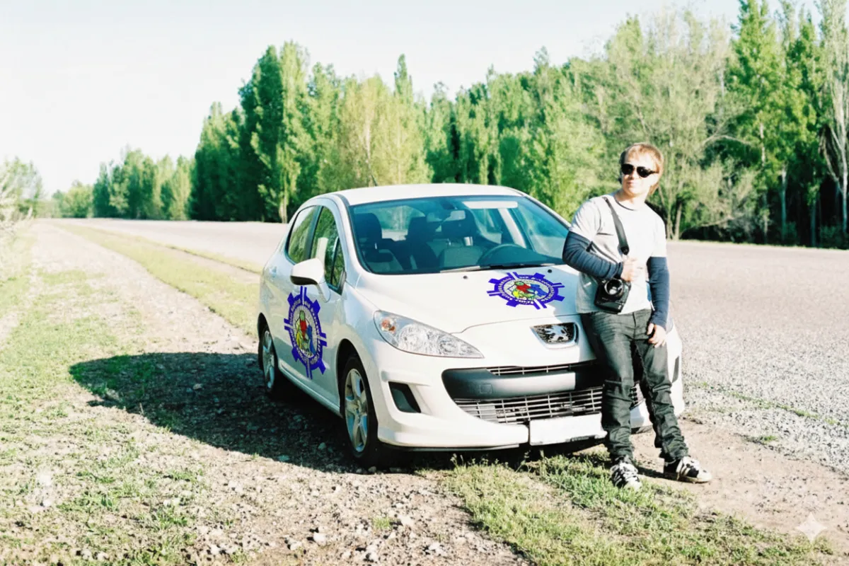 a man standing next to a car on a dirt road