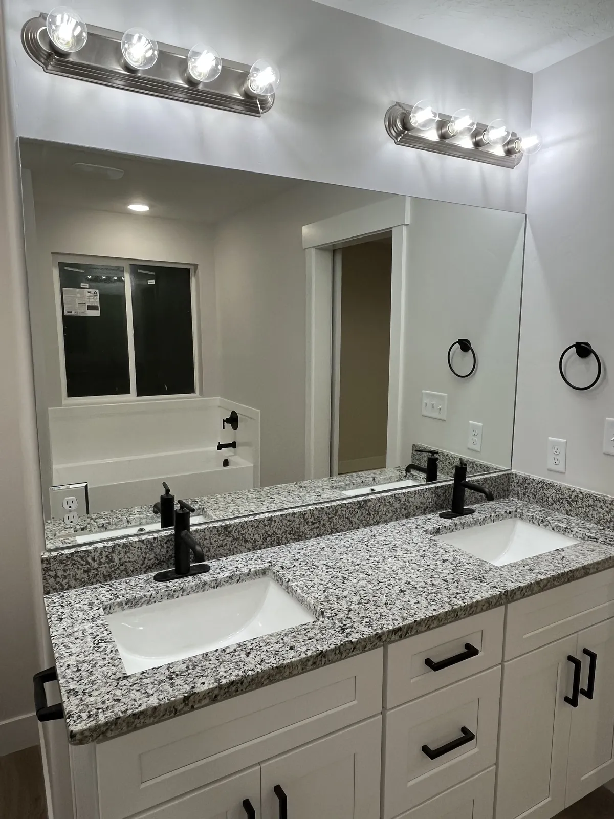 Wide vanity mirror above a granite double vanity