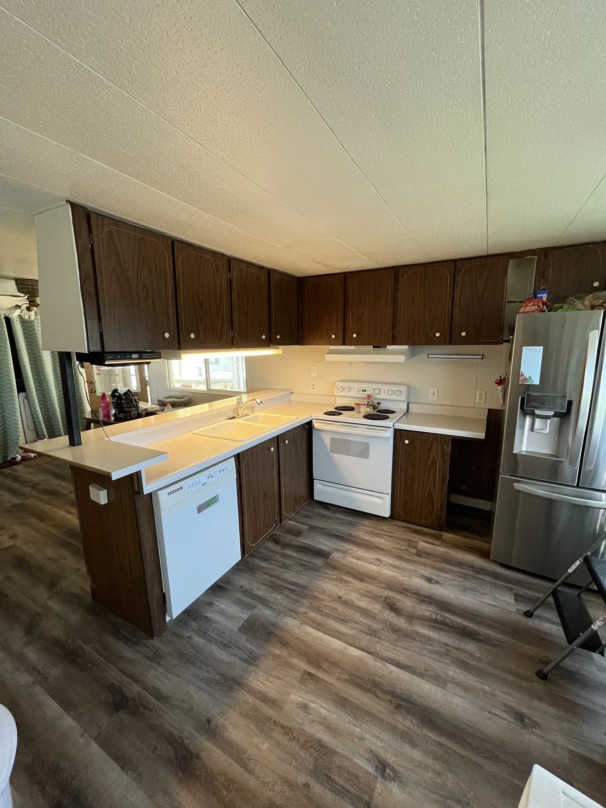 Kitchen with dark wood cabinets and stainless refrigerator