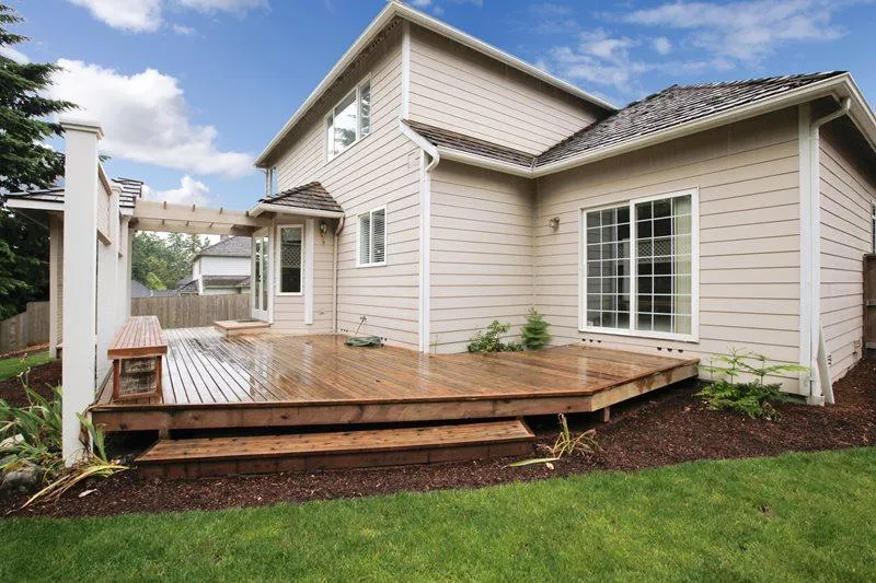 Technician power washing a weathered deck before refinishing