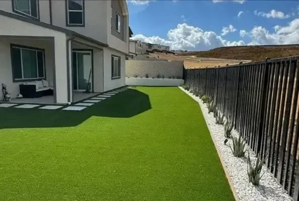 a dog sitting on a patio next to a chair
