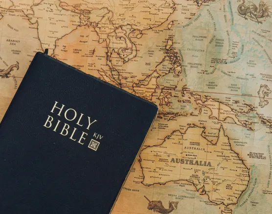 Bible resting on ancient map representing historical context