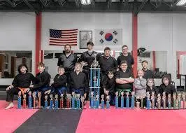 Group of tae kwon do students with trophies