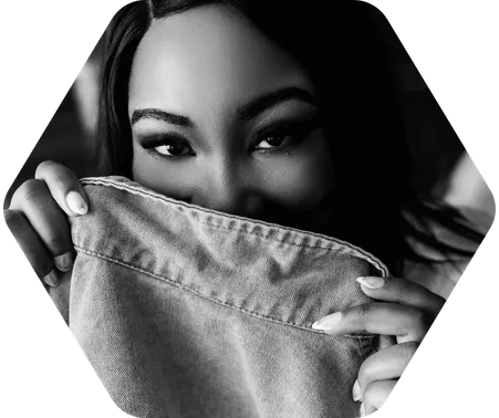 A woman in lingerie poses with half her face covered by a jean jacket for a boudoir shoot in Indianapolis at Enchanted Moments Artistry