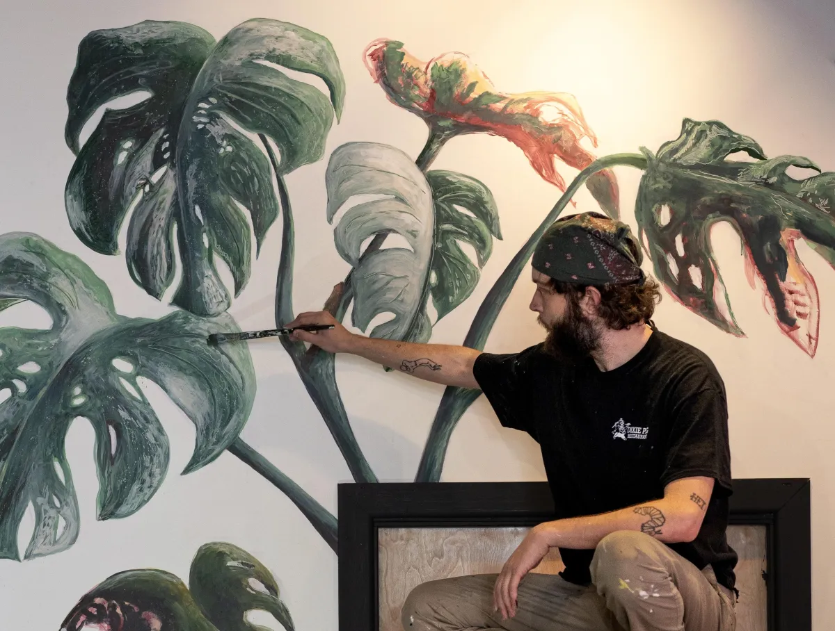 David Reynaud painting a leaf mural.