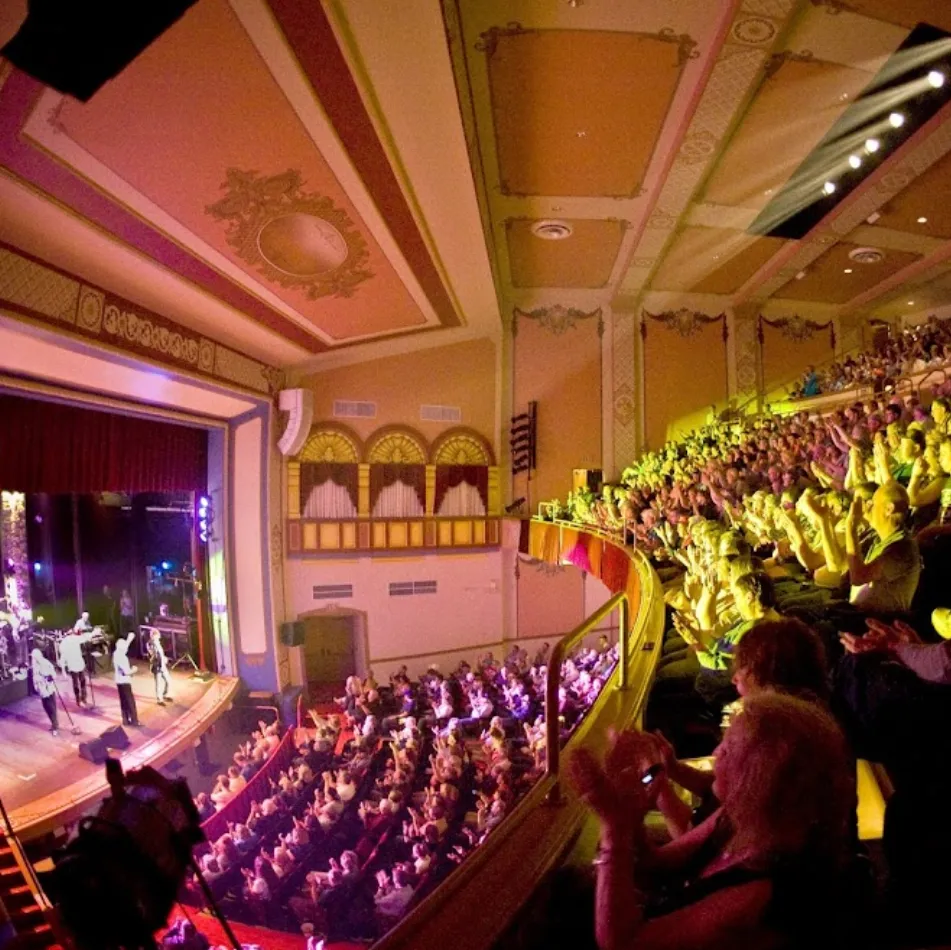 rows of people in theater watching a live band perform on stage in marietta oh