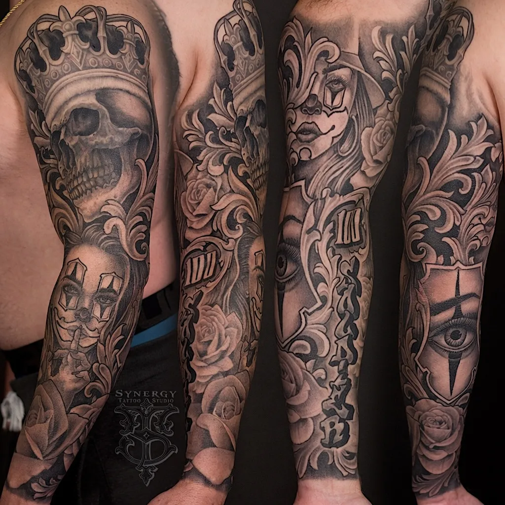 Black and grey tattoo sleeve combining a crowned skull, portrait, and ornamental scrollwork