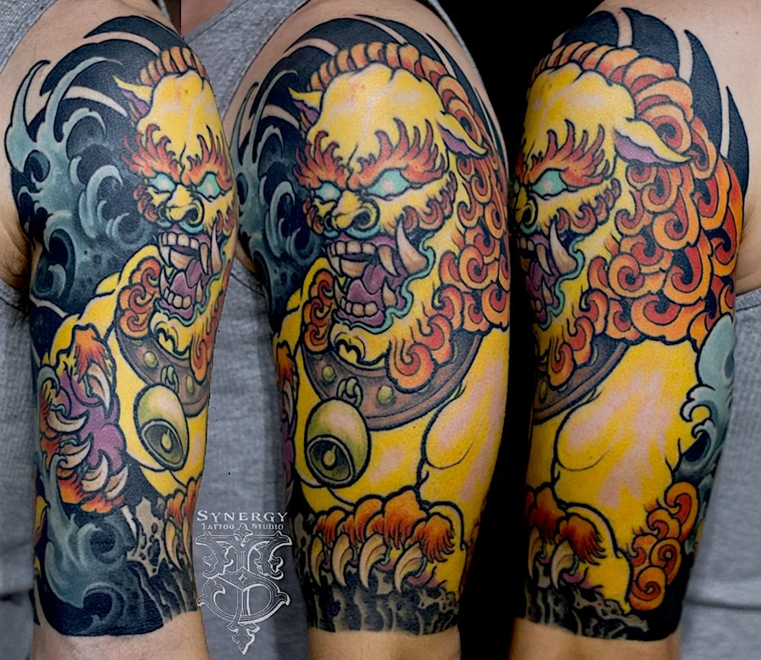 Yellow and orange Japanese guardian lion tattoo with dark blue waves
