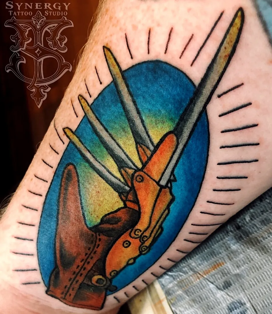 Wolverine clawed hand tattoo against a blue oval background