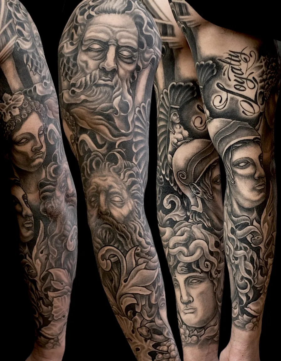 Black and grey tattoo sleeve with classical sculpted faces and flowing ornamental details