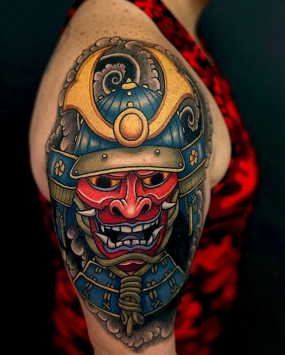 Red Japanese mask tattoo beneath an ornate samurai helmet