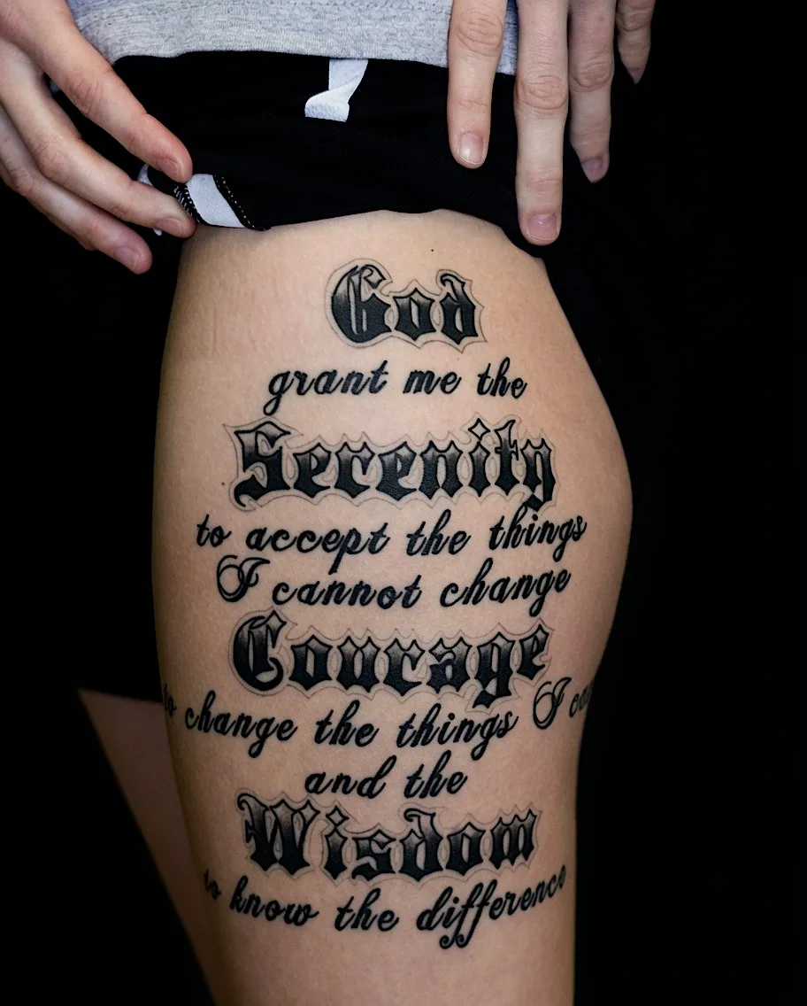 Serenity Prayer lettering tattoo on the thigh