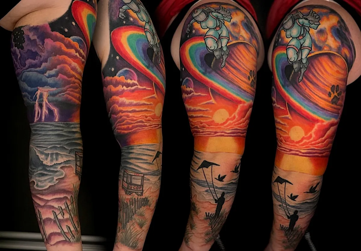 Color fantasy tattoo sleeve blending dramatic skies, ocean scenery, and warm sunset colors
