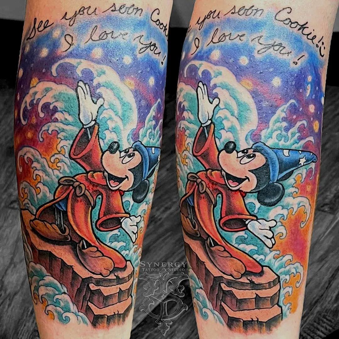 Color Sorcerer Mickey tattoo surrounded by bright swirling clouds
