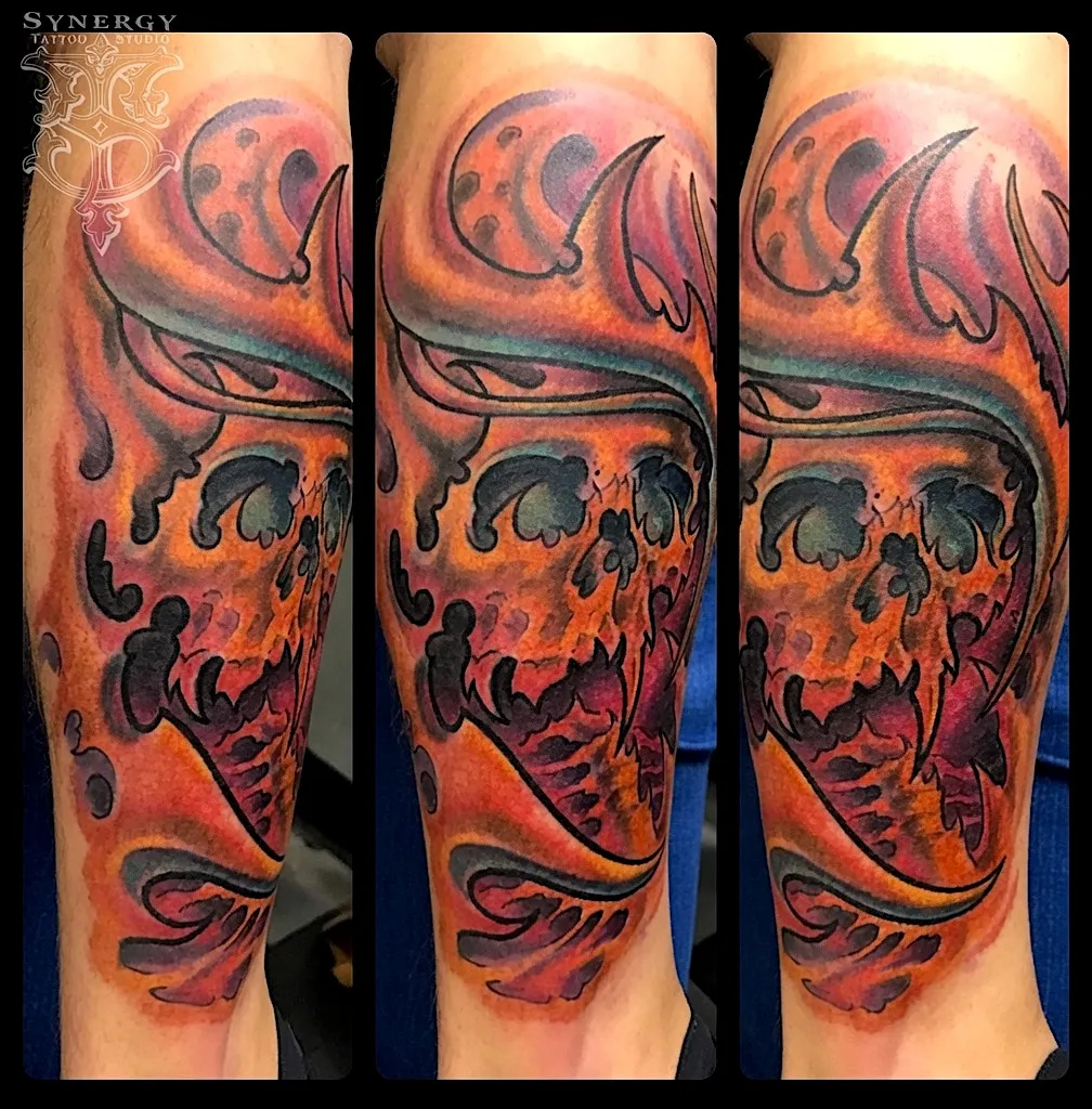 Orange and red skull tattoo with flowing organic shapes