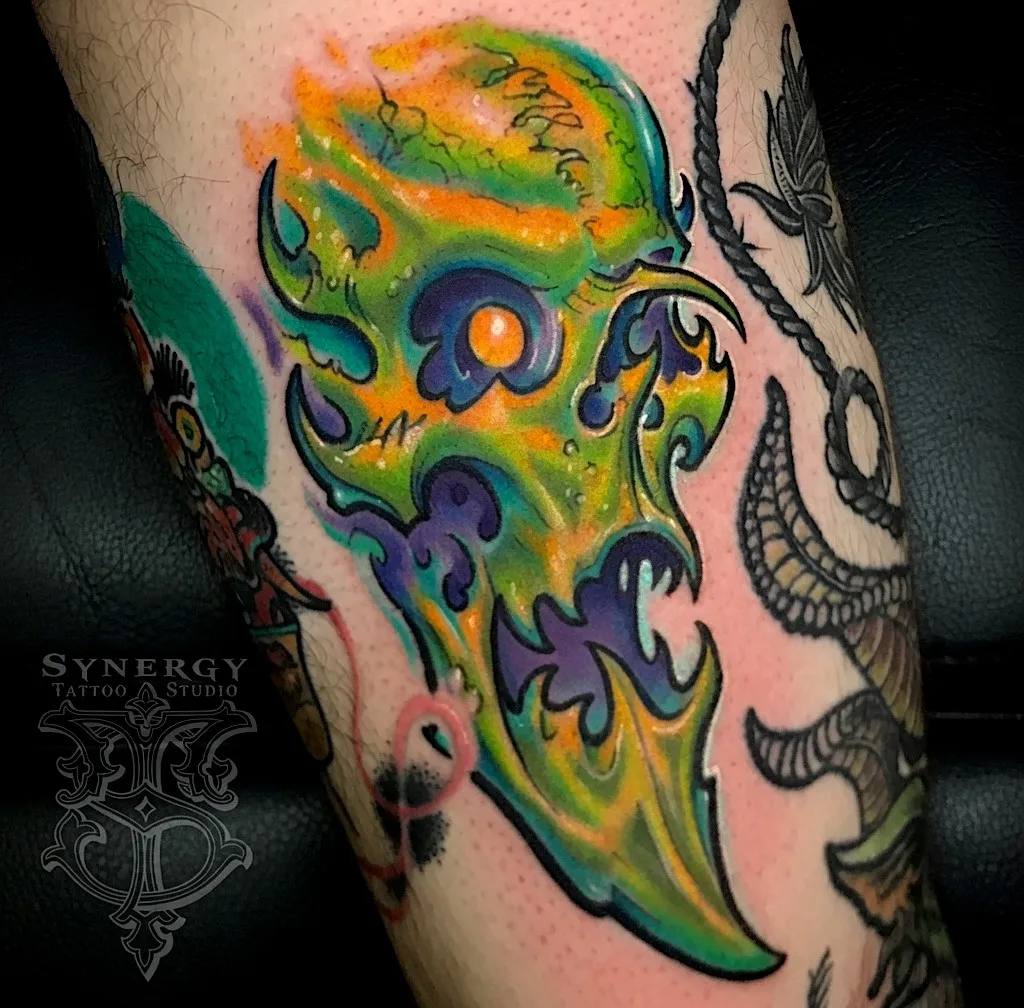 Glowing green and yellow flame-shaped skull tattoo