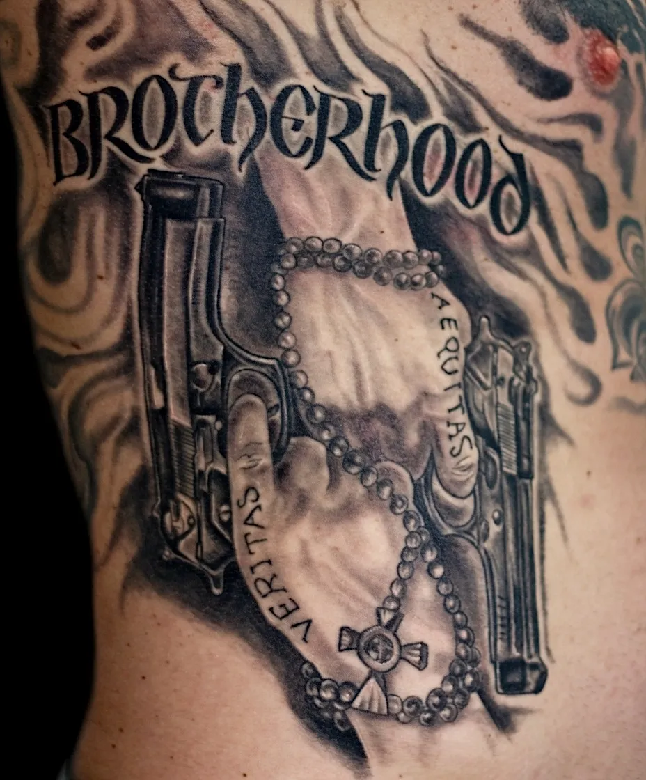 Black and grey Brotherhood tattoo with hands holding pistols and a rosary