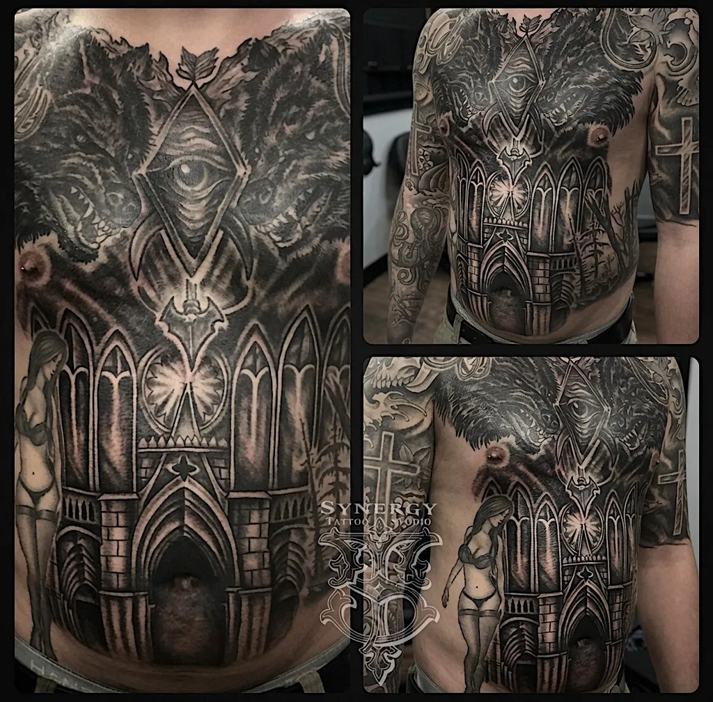 Black and grey torso tattoo combining a gothic cathedral, wolves, and an eye motif