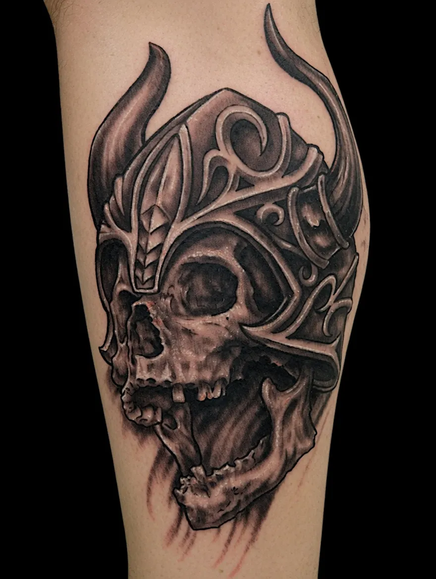 Black and grey skull tattoo wearing an ornate horned helmet