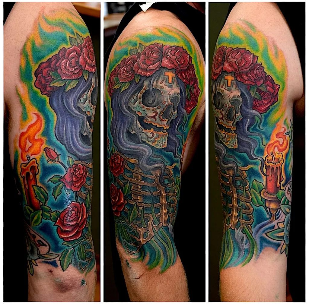 Color skull tattoo with flowing blue hair, red roses, and green flames