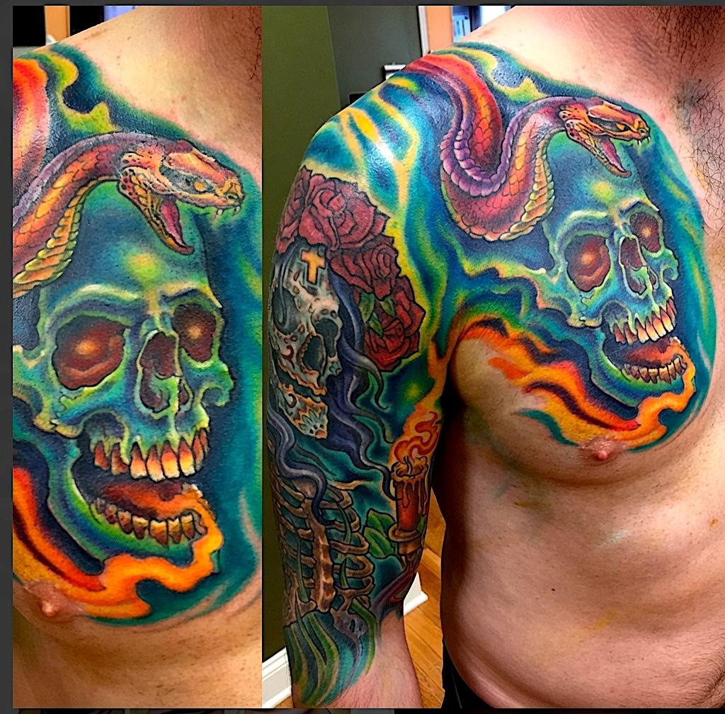 Brightly colored skull and snake tattoo across the chest and shoulder