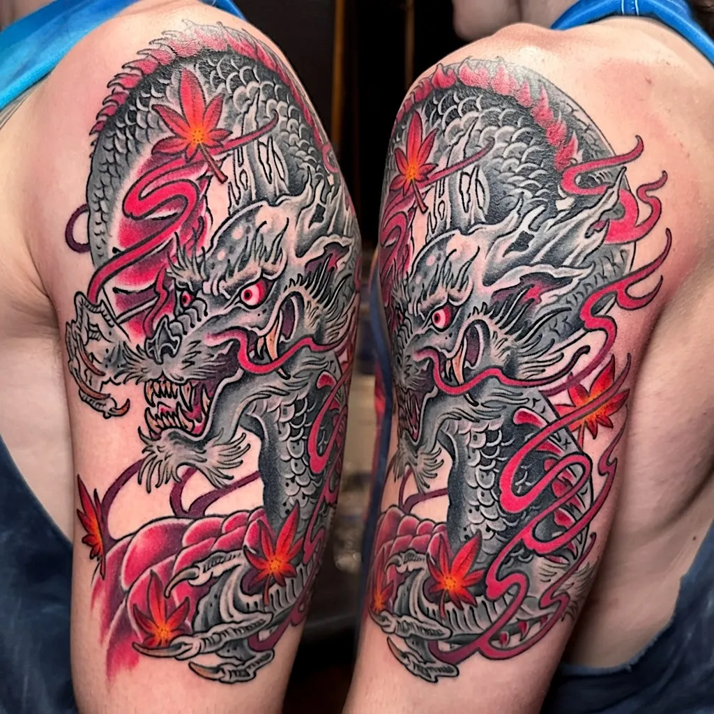 Black and grey dragon tattoo with red ribbon lettering and flowers