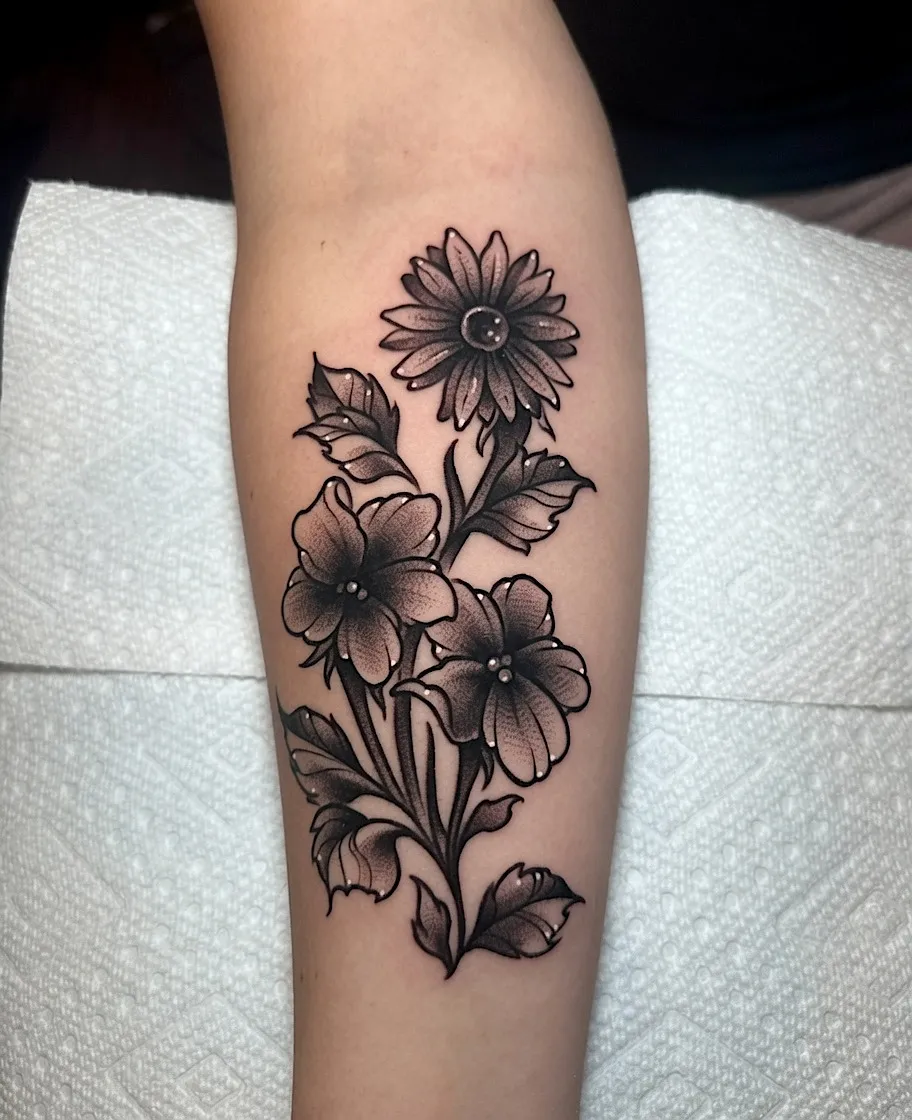 Black and grey sunflower and blossom tattoo with leaves