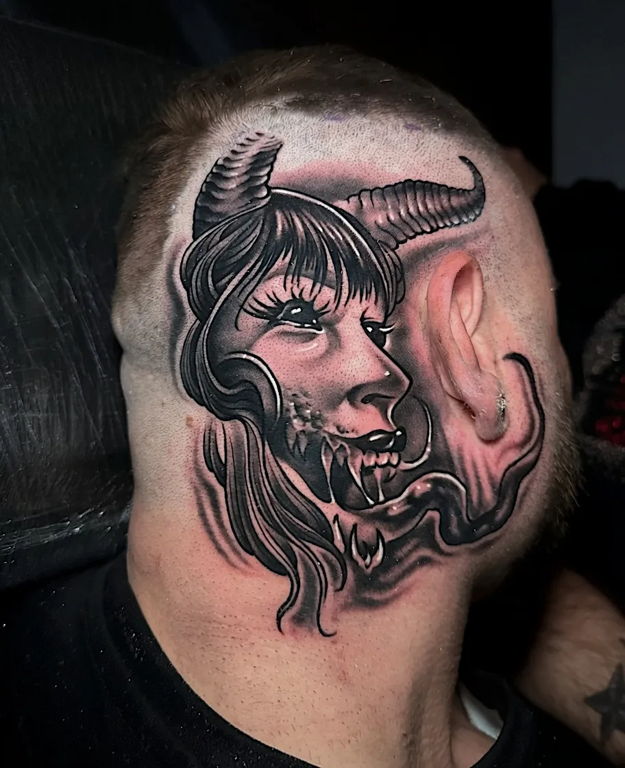 Black and grey horned woman’s portrait tattoo on the side of the head