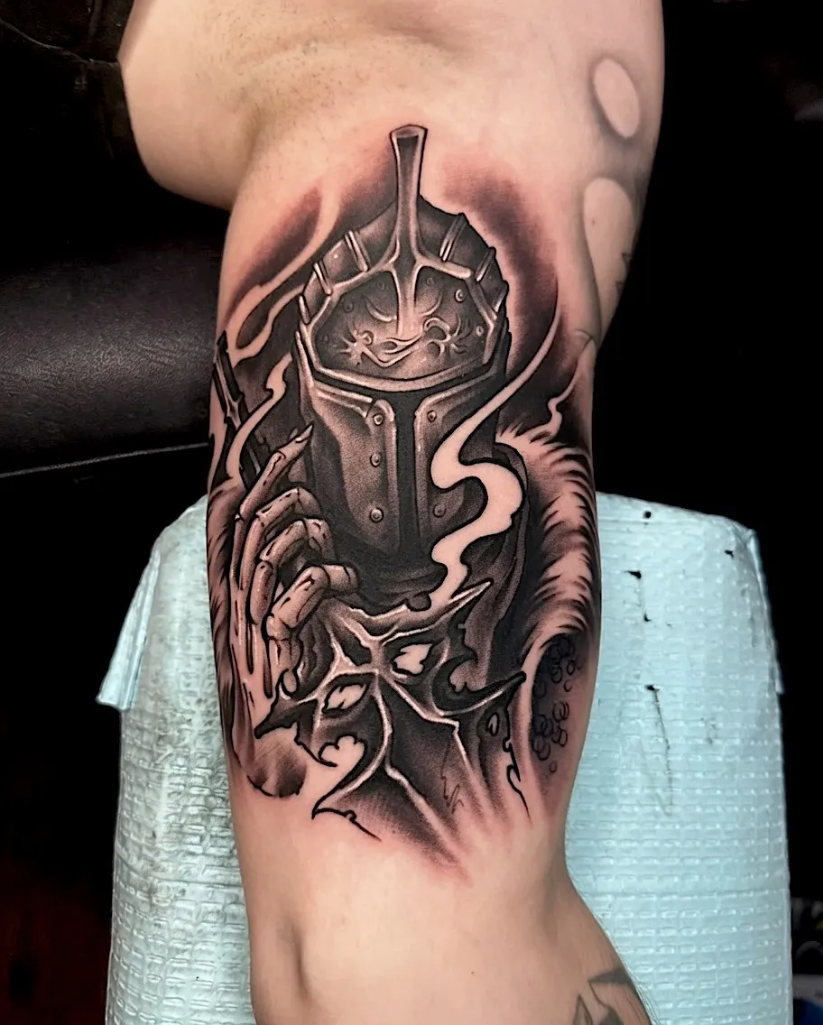 Black and grey armored knight helmet tattoo with a skeletal hand