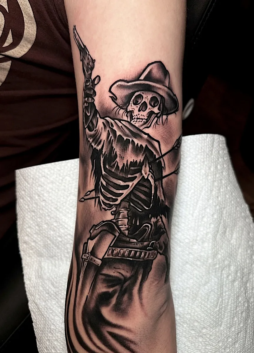 Black and grey skeleton cowboy tattoo with a hat and bandolier