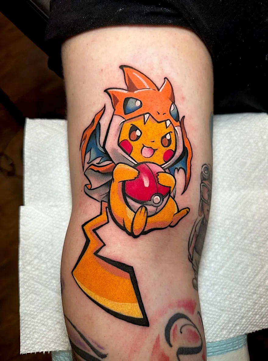 Color Pikachu tattoo wearing a Charizard costume and holding a Poké Ball