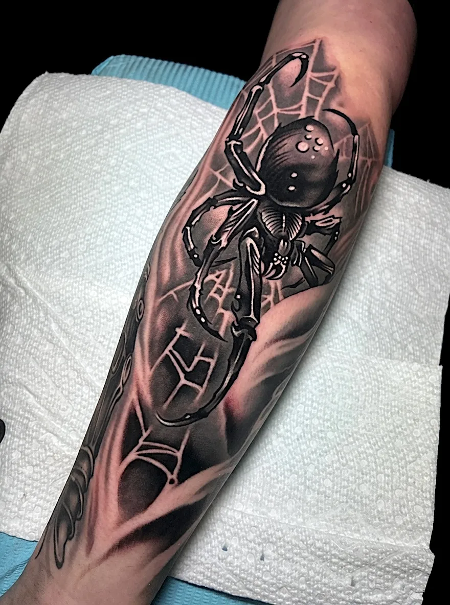 Black and grey spider tattoo with a dark geometric web
