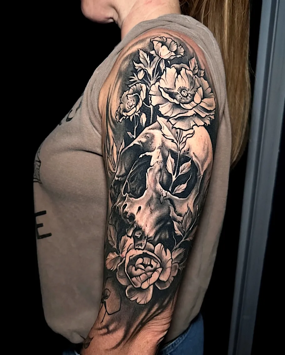 Black and grey skull tattoo framed by roses