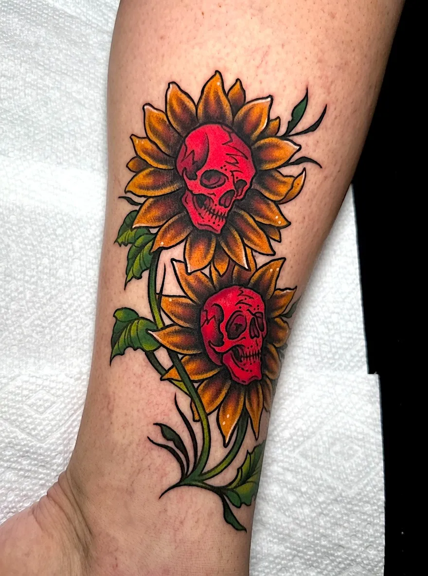 Sunflower tattoo with red skulls at the centers of the flowers