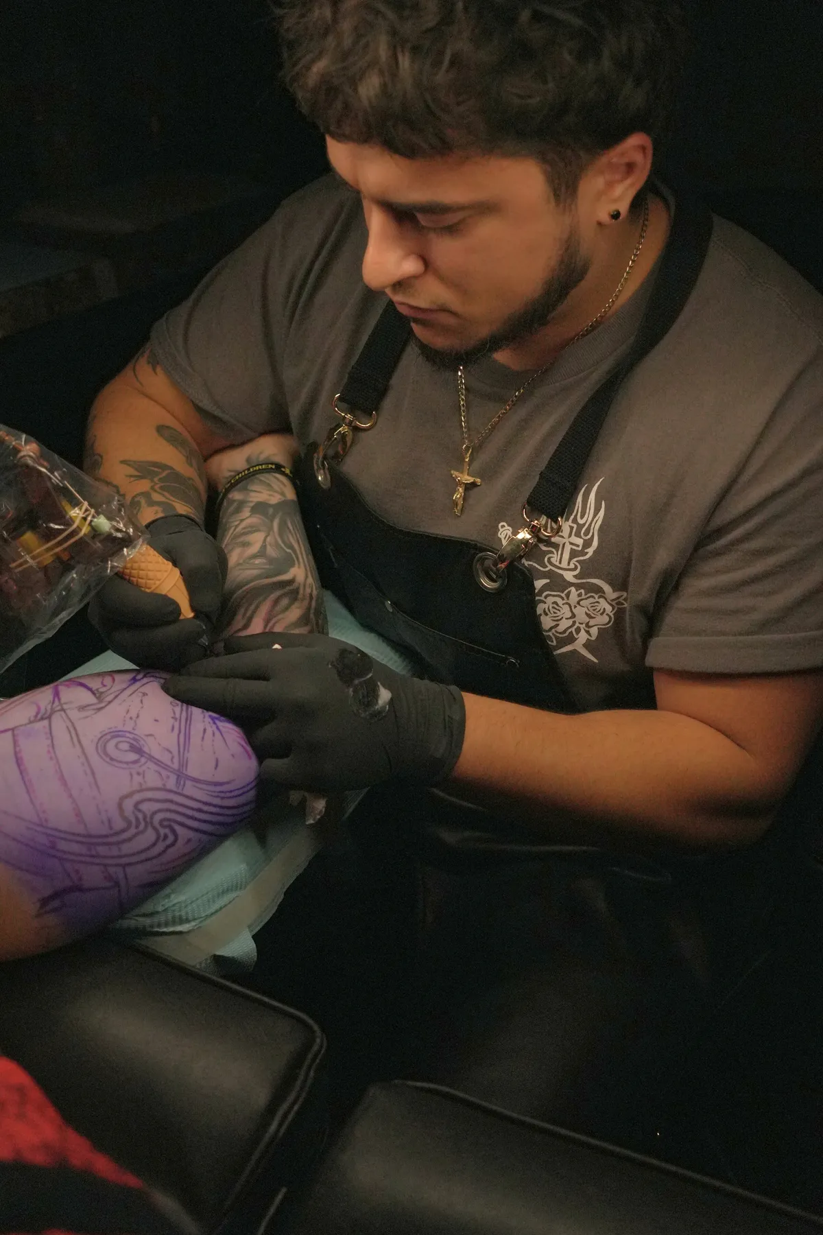 Dylan Landicini tattooing a client’s leg at Synergy Tattoo Studio