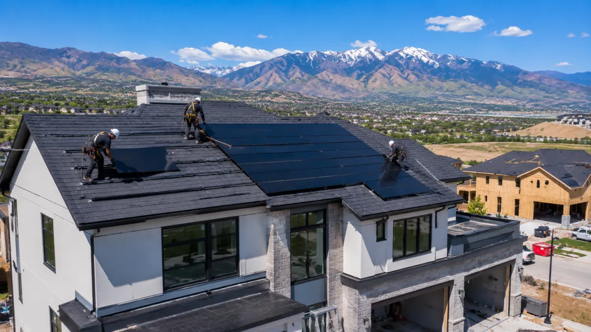Installers placing Tesla solar panels on a new Lehi home in Silicon Slopes
