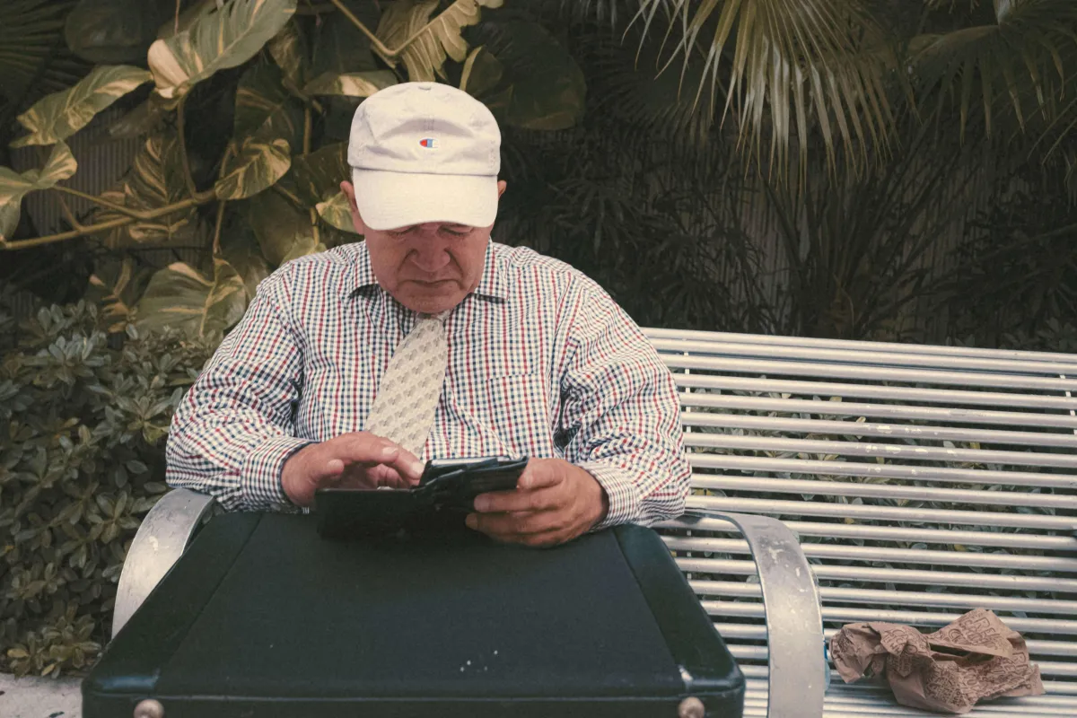 Old man using phone to enroll in medicare