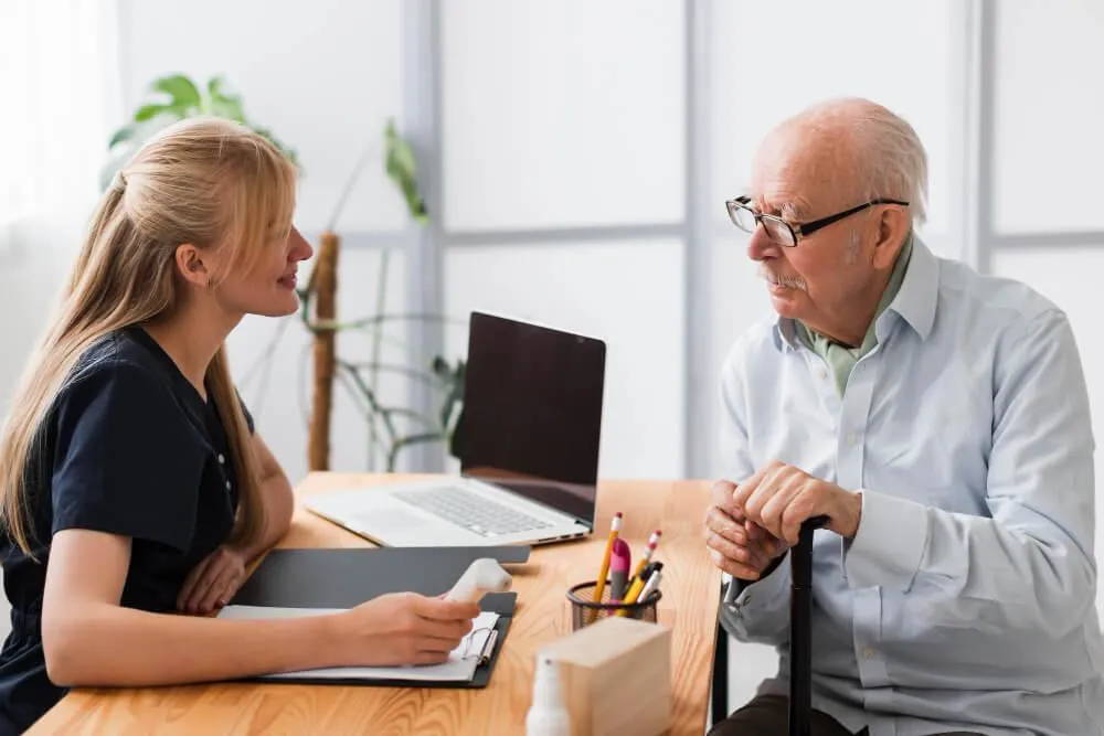 Woman assisting old man about his insurance
