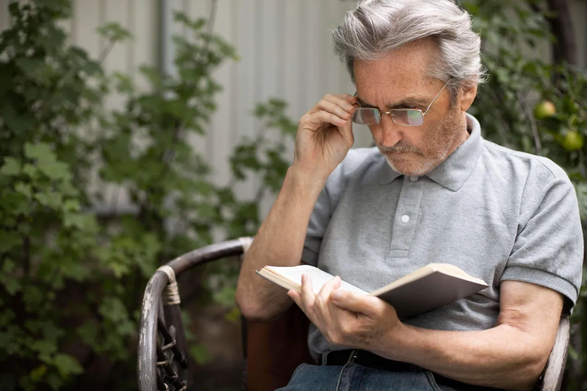 Old Man Reading Handbook about Medicare